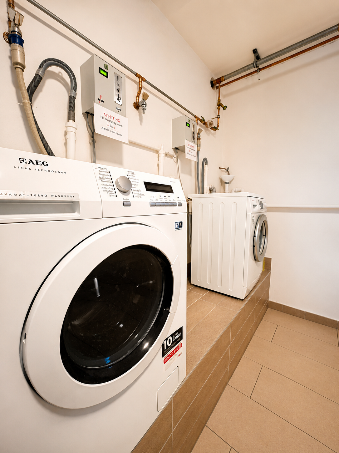 Waschmaschine und Trockner (AEG) im Waschraum der Pension